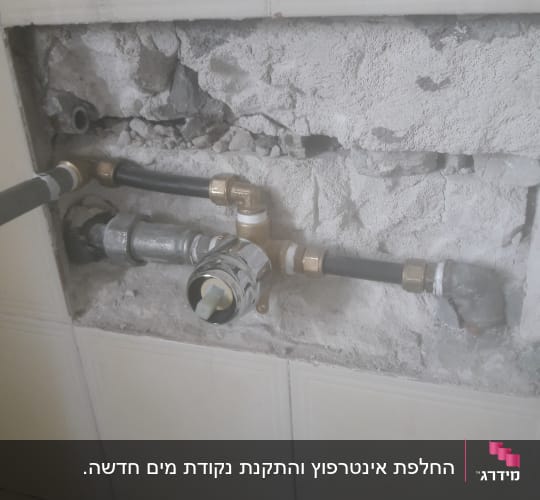 צנרת מים חשופה בקיר עם חיבורים